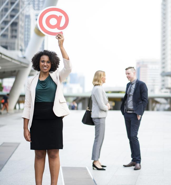 business woman holding email symbol in her hand on the street