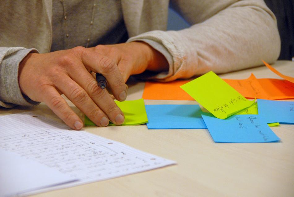 Brainstorming, person at desk with notebook and colorful stickers