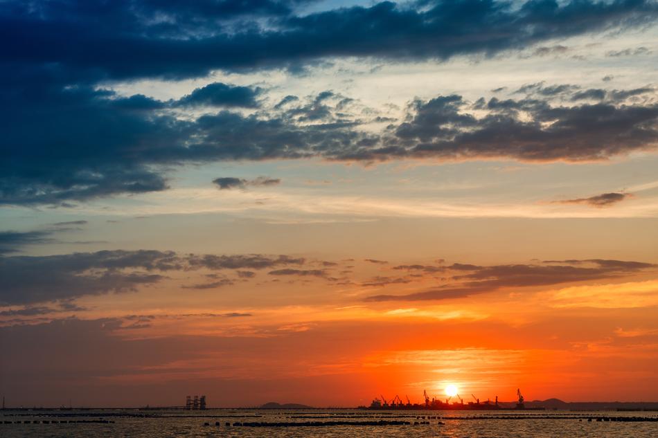 sunset over an industrial area on the horizon
