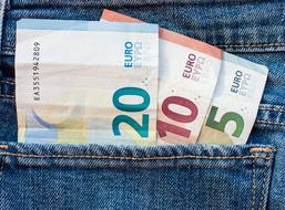 Colorful Euro bills in the pocket of blue jeans