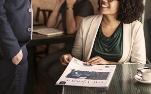 african american woman with newspaper in cafe