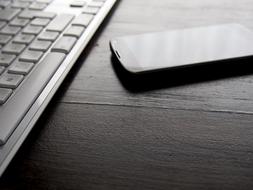 smartphone with computer keyboard on a desk