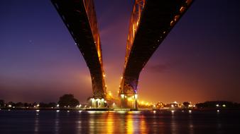 Beautiful landscape with the bridge, above the water, with the colorful lights, at the night