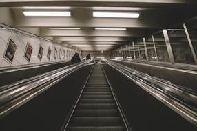 black and white photo of escalators in the subway