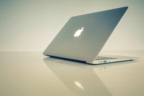 white macbook on a white table