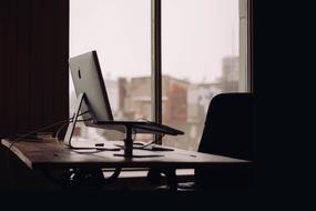 Office desk with the Mac computer and window behind