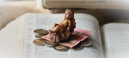 figurine of an angel and money on an open book