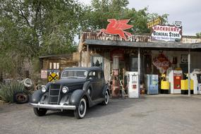 black vintage car on the background of an old gas station