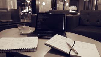 Laptop among the notebooks on the table