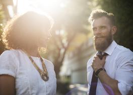 man in tie and woman communicating outdoor