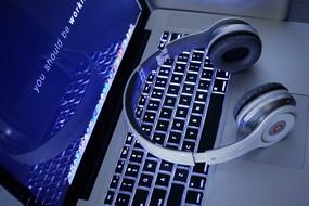 headphones keyboard and monitor desk