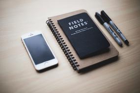 smartphone on the table next to the notebook