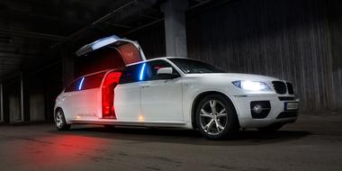 long white Limousine with open door at night