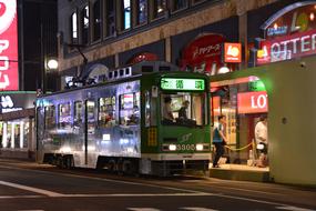 Green tram on a street in Sapporo, Japan