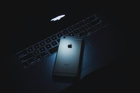 photo of an iPhone on a laptop in the dark
