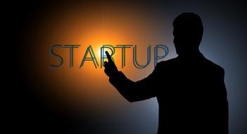 Startup, silhouette of man pointing to lettering, drawing