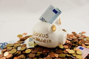 piggy bank with a banknote stands on a pile of coins