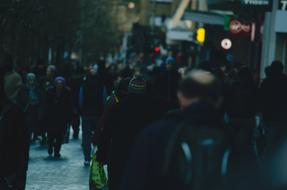 People, walking on the street, with the colorful signs, in the evening