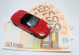 red toy car on euro bills