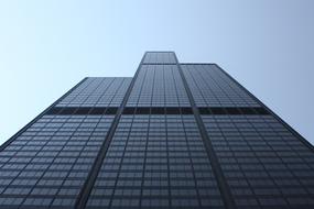 Low angle shot of the beautiful, glass building, at blue sky on background, in light