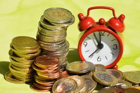 Shiny coins near the red, white and black clock