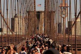 People, on the beautiful Brooklyn Bridge with the American flag, in New York, in America