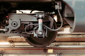 Close-up of the wheel and mechanism of a train, on the railway, in light