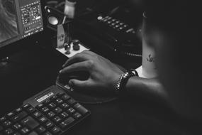 black and white photo of a man at work near a computer