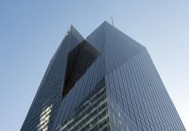 Low angle shot of the shiny building in New York, USA, with the windows, under the blue sky, in sunlight