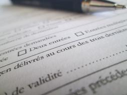 Close-up of the shiny pen, on the papers, with French text