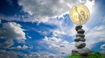 gold dollar balancing on a pyramid of stones