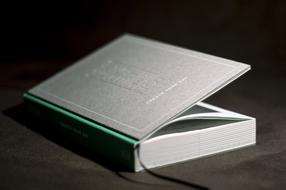 Beautiful, grey and green book with black bookmark among the darkness