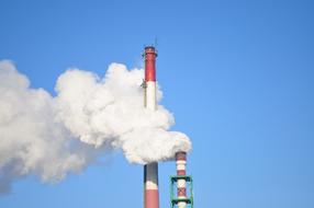 two Industrial chimneys and smoke at sky