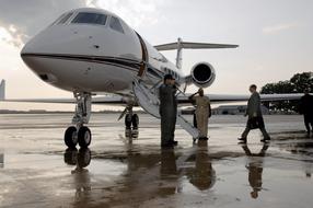 "Gulfstream V" aircraft on the wet lane of the airport, at colorful sunrise