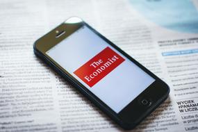 Black Iphone with the white screen and red and white "The Economist" sign, on the newspaper