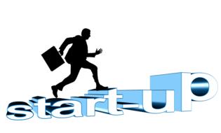 Black silhouette of a man with a suitcase, walking on a blue and white "start-up" sign, at white background, on clipart