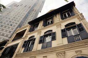 black shutters on windows and facade of an old building in Singapore, Asia