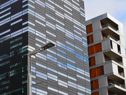 Colorful, shiny office buildings, in light, under the blue sky with white clouds
