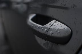 car handle in raindrops close up