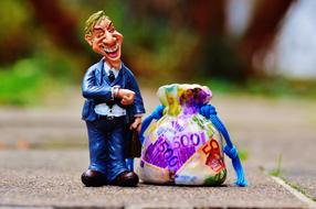 Figure of the businessman, with the colorful bag, with the banknotes