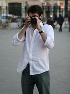 Man in white shirt, taking a photo with camera