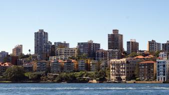 Colorful buildings in the shore of Sydney, with the green trees, in Austria, under the blue sky
