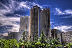 Beautiful cityscape of Madrid, among the green trees, under the blue sky with white clouds, in Spain