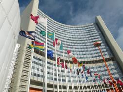 Colorful flags near the International Center in Vienna, Austria, at blue sky with white clouds on background