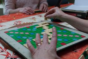 People playing board game with the colorful board with squares