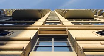 Low angle shot of the beautiful, yellow building with windows, in light, in New York City, USA