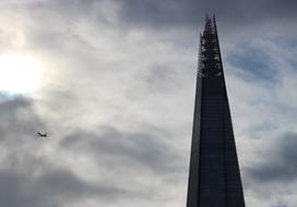 airplane in the clouds above the city tower