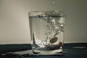 coins float in a glass of water