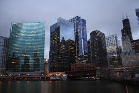 Beautiful cityscape of Chicago, with colorful lights in the evening, on the shore of the Chicago River, under the cloudy sky, in Illinois, USA