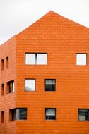 Orange, brick building with the shiny windows in Amsterdam, Netherlands